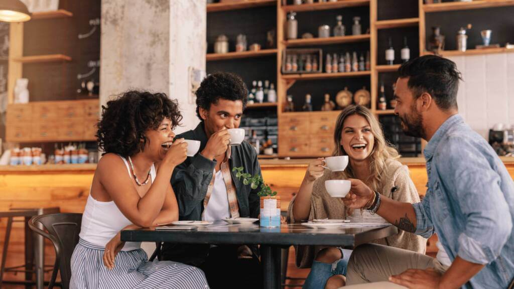 Friends talking at a coffee shop with calm expressions