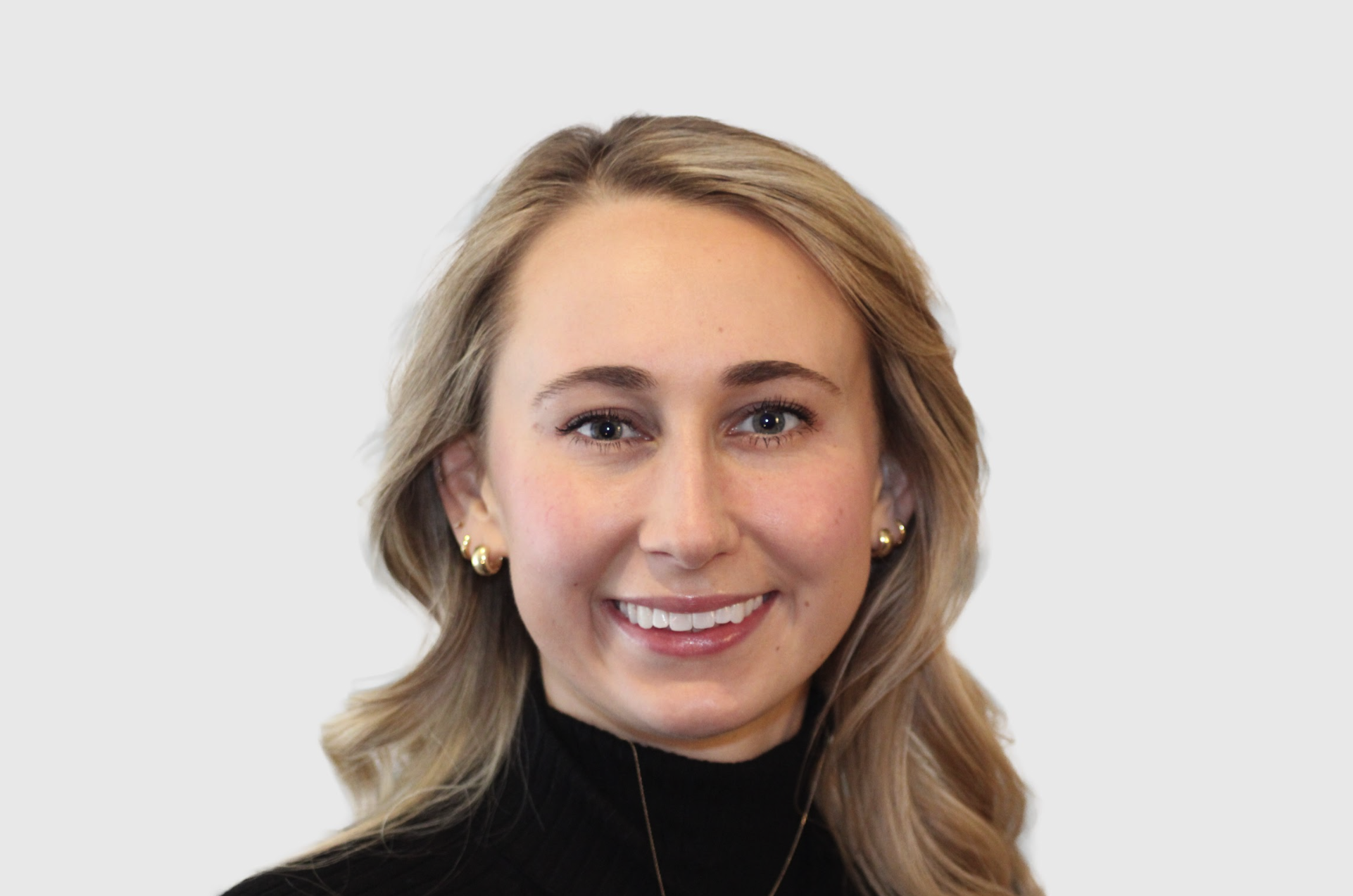 Hannah Bushner, blonde female couple and family therapist, smiling and showing teeth while wearing gold small hoop earrings