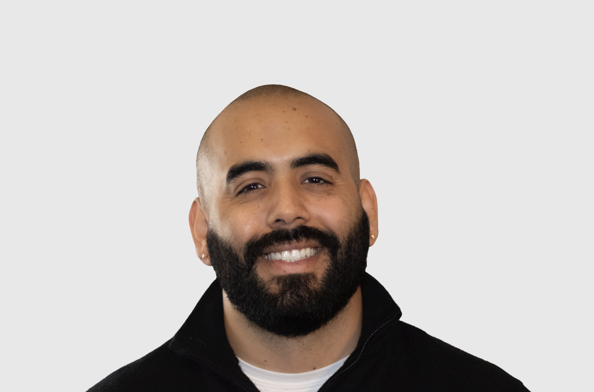 Grant Morales, Latino male couples and family therapist, bald with dark beard, pierced ears, brown eyes, smiling