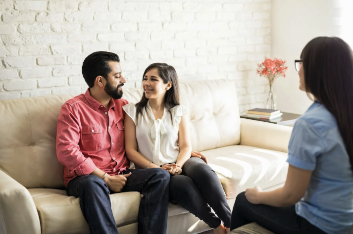 heterosexual couple on the couch during couples therapy smiling