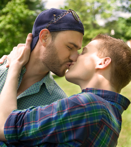 Two men sharing a kiss outdoors, symbolizing love, intimacy, and LGBTQ+ relationships