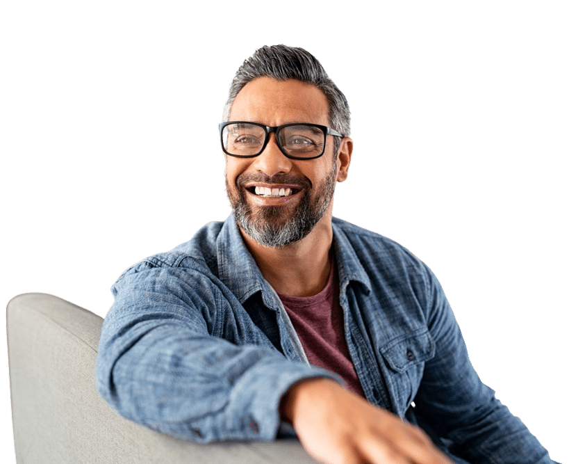 Smiling man with glasses and beard sitting casually in denim shirt